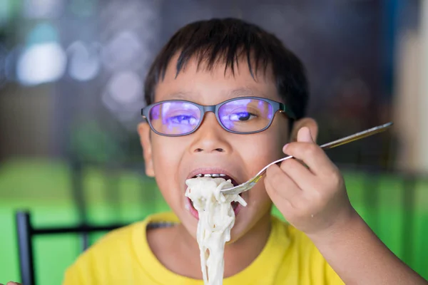 Crianças asiáticas usam óculos com luz azul bloqueando e comendo — Fotografia de Stock