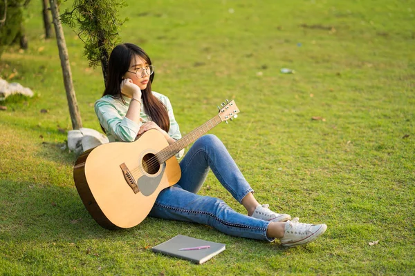 A menina bonita cabelo longo sentar-se no campo olhar vago — Fotografia de Stock