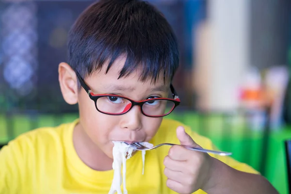 Asian children wear glasses with blue light blocking and eating