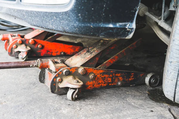 Jack levanta carro de manutenção na garagem — Fotografia de Stock