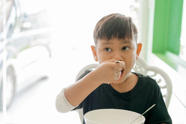 Os meninos nas mãos feridas comendo arroz sozinho — Fotografia de Stock