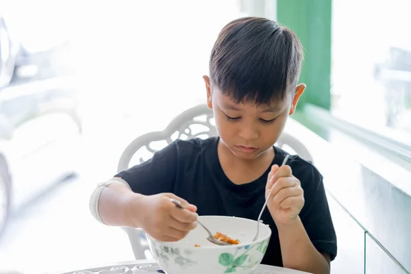 Os meninos nas mãos feridas comendo arroz sozinho — Fotografia de Stock