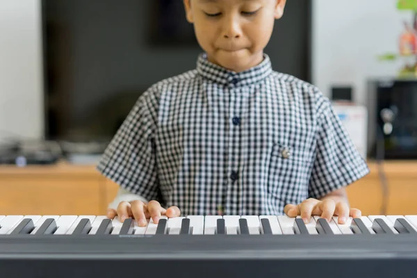 Un asiático chicos en las manos heridas tocando el piano, aprendizaje de piano — Foto de Stock