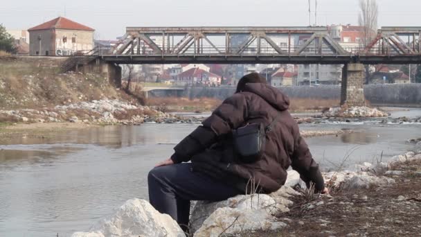 Homme Assis Sur Pierre Près Rivière Jetant Des Cailloux Dans — Video