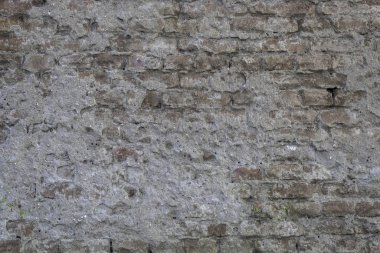 Betonla kaplanmış eski püskü tuğla duvar.