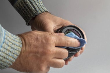 Man Hands Holding Camera Lens and Cleaning It Using Cleaning Cloth