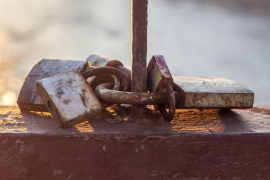 Paslı asma kilitler Nehrin yukarısındaki köprüde bir desteye kilitlendi