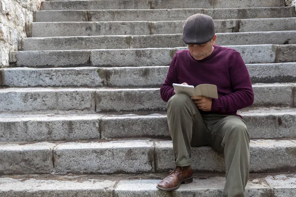 Taş Merdivenlerde oturan ve Tabletle oynayan Orta Çağ Adamları