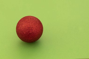 Kırmızı Noel Dekoratif Balosu Yeşil Arkaplanda Sol Tarafta. Boşluğu Sağ Tarafa Kopyala