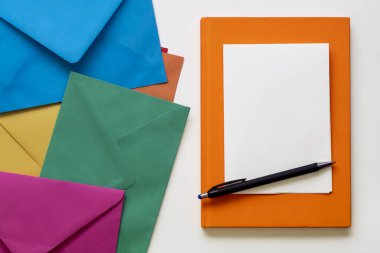 Metin için Renkli Dağılmış Zarflar, Siyah Kalem, Turuncu Not Defteri ve Boş Beyaz Kağıt Kullanılarak Yaratıcı Bileşim