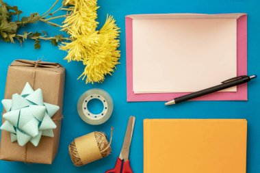 Metin, Kara Kalem, Sarı Çiçekler, Koli Bandı, Makas, Paket İpliği, Not Defteri ve Hediye Kutusu İçin Pembe Zarf, Boş Kağıt Kullanımı