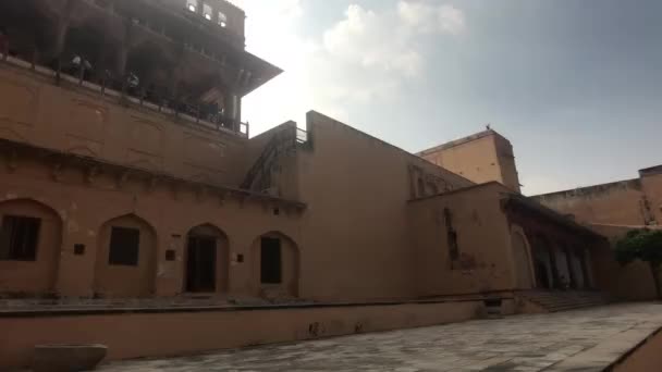 Jaipur, Indien, 05 november 2019, Amer Fort, en turist promenader längs väggen i en gammal byggnad — Stockvideo