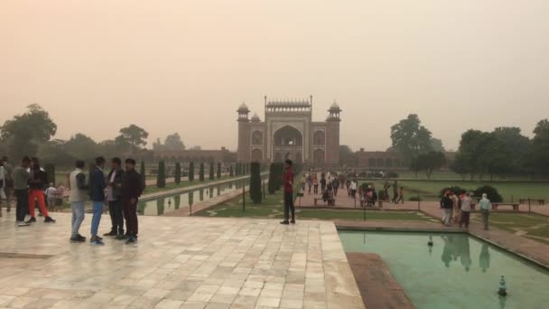 インドのアグラ、 11月10 、 2019 、 Taj Mahal 、観光客はモスクの背景で話す — ストック動画