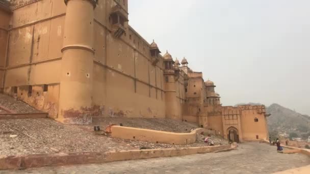 Jaipur, India, 05 de noviembre de 2019, Amer Fort grand fortress walls and tourists walking below — Vídeos de Stock