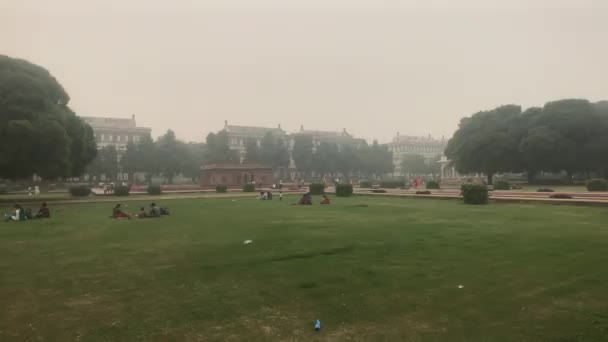 New delhi, Indien, 11. November 2019, Touristen sitzen bei schlechtem Wetter auf dem Rasen — Stockvideo
