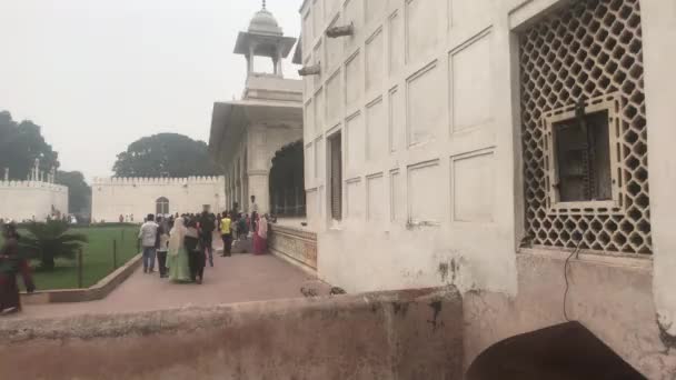 Új-Delhi, India, 2019. november 11., turisták sétálnak az építészeti épületek mentén — Stock videók