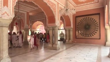 Jaipur, Hindistan - 4 Kasım 2019: Pembe bir binanın duvarlarının yanından geçen şehir sarayı turistleri