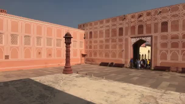 2019年11月4日，印度斋浦尔：城市宫的游客走过一座粉红色建筑的墙壁 — 图库视频影像