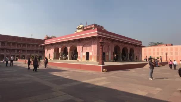 Jaipur, Indie - 4. listopadu 2019: Turisté z Městského paláce kráčejí na pozadí budovy s růžovými zdmi, část 2 — Stock video