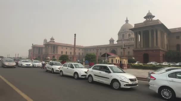 New Delhi, India, 11 november 2019, auto 's staan op de achtergrond van een oud gebouw in de hoofdstad — Stockvideo