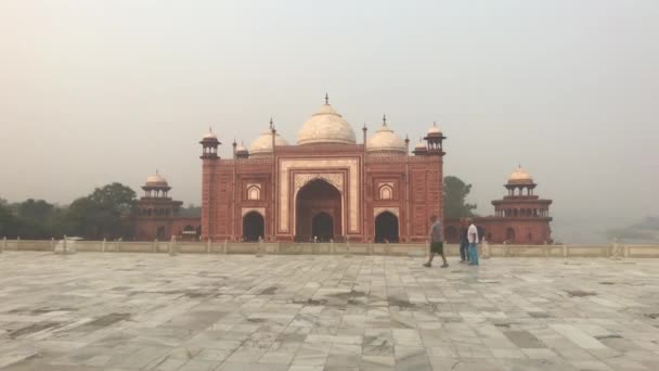 Agra, Índia, 10 de novembro de 2019, Taj Mahal, turistas passam por uma mesquita auxiliar — Vídeo de Stock