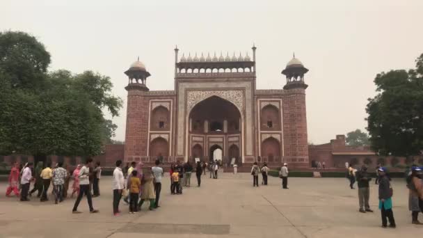 Agra, India, 2019. november 10., Taj Mahal, egy turistacsoport egy mecset meglátogatása előtt — Stock videók