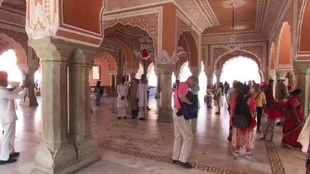 インドのジャイプール- 11月4 、 2019:観光客の都市宮殿グループがホールに立って話し合う — ストック動画