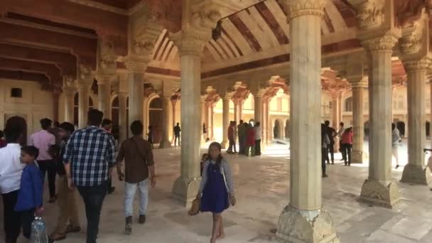 Jaipur, Indie, 5. listopadu 2019, Amer Fort, turisté procházejí ve stínu baldachýnu s bílými sloupy — Stock video