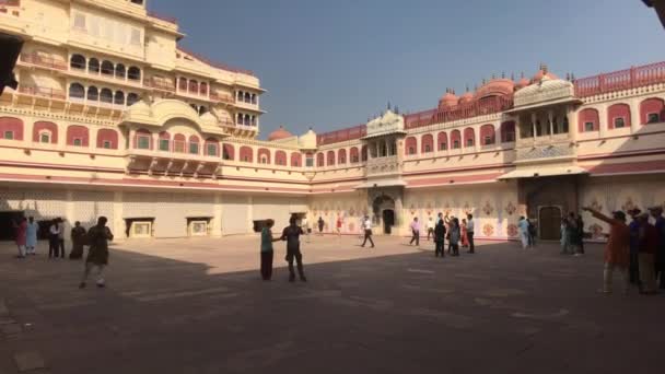 Jaipur, India - 04 november 2019: City Palace toeristen bekijken de muren van een prachtig gebouw — Stockvideo