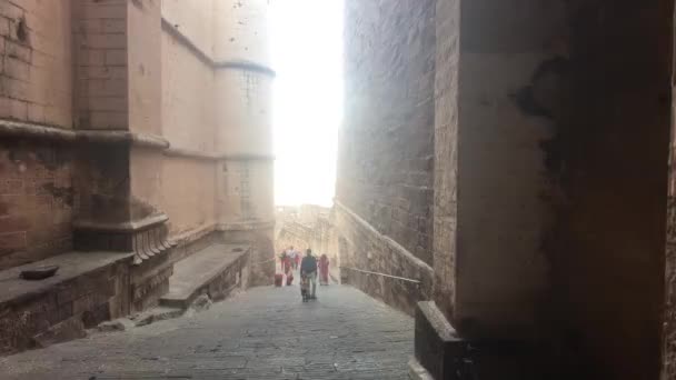 Джодхпур, Індія - 6 листопада 2019: Туристи форту Мехрангарх ідуть вузьким коридором старої фортеці. — стокове відео