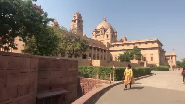 Jodhpur, India - November 06, 2019: Umaid Bhawan Palace tourists pass by neat buildings part 2 — Stock Video