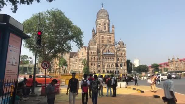 Mumbai, India - 10 november 2019: Chhatrapati Shivaji Terminus toeristen lopen langs het gebouw van de gemeentelijke corporatie — Stockvideo