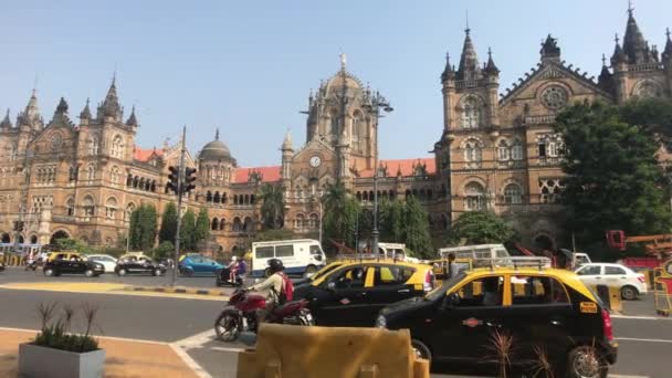 Mumbai, India - November 10, 2019: Chhatrapati Shivaji Terminus tourists drive past the station building — ストック動画