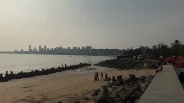 Mumbai, indien - 10. November 2019: marinegetriebene Touristen spazieren die Böschung entlang — Stockvideo