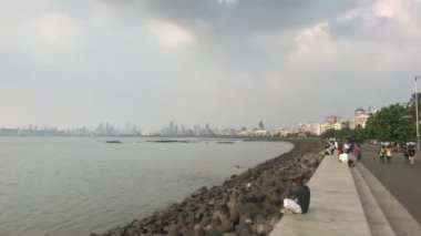 Mumbai, Hindistan - 10 Kasım 2019: Sahil kenarında yürüyen turistler