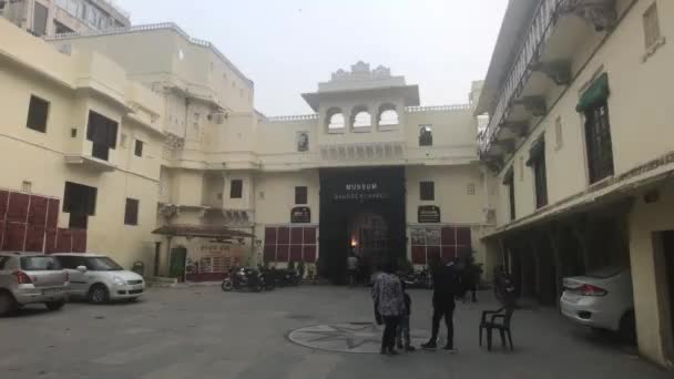 Udaipur, India - 12 de noviembre de 2019: los turistas se relajan a la sombra del edificio parte 2 — Vídeos de Stock