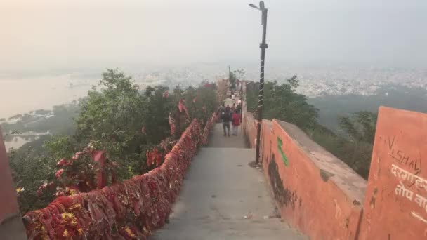 Udaipur, Indie - 12. listopadu 2019: Turisté z Mansapurny Karni Mata Ropeway se procházejí na vrcholu hory — Stock video