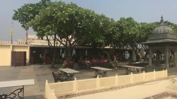 Udaipur, Indie - 12 listopada 2019: Turyści Jaguara Mandira piją kawę na otwartym terenie — Wideo stockowe