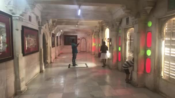 Udaipur, Índia - 13 de novembro de 2019: Os turistas do Palácio da Cidade tiram fotos de paredes dentro de quartos — Vídeo de Stock