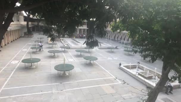 Udaipur, Indie - 13 listopada 2019: Turyści City Palace spacerują w pobliżu stołów na podwórku — Wideo stockowe