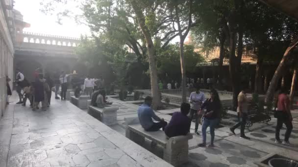 ウダイプール、インド- 11月13 、 2019:シティパレス観光客は歴史的な建物の中庭でリラックスします — ストック動画