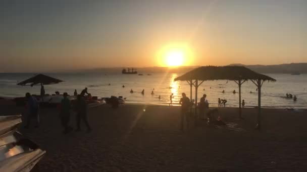 Акаба, Иордания - 15 октября 2019 года: туристы на вечернем пляже Красного моря, часть 2 — стоковое видео