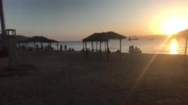 Akabe, Ürdün - 15 Ekim 2019: Kızıldeniz 'in akşam plajında turistler