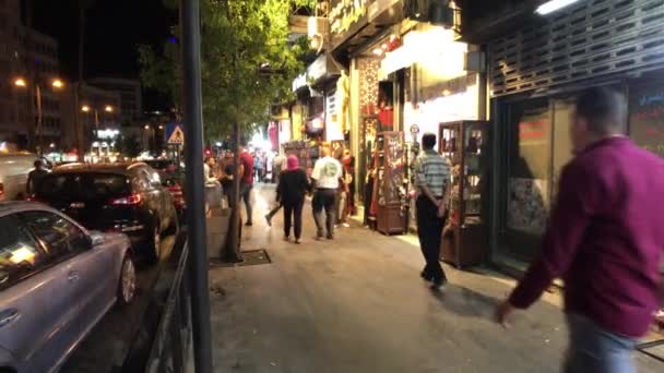 Amman, Jordan - 15 жовтня 2019: туристи проходять через нічне місто вздовж магазинів 3-го стовпчика — стокове відео