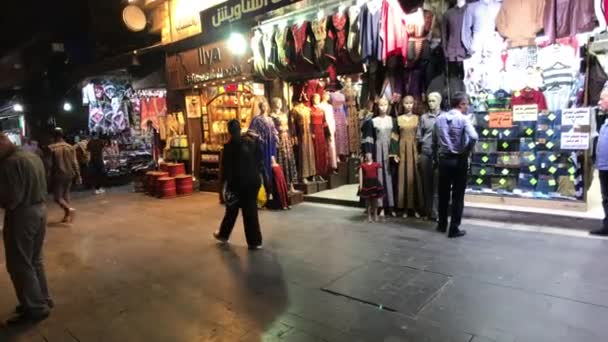 Ammán, Jordania - 15 de octubre de 2019: los turistas caminan por la ciudad nocturna a lo largo de las tiendas par 5 — Vídeos de Stock