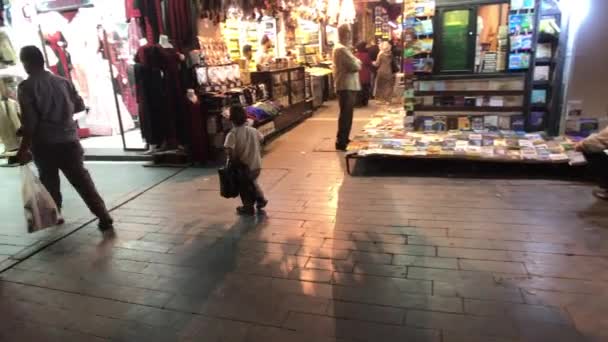 Ammán, Jordania - 15 de octubre de 2019: los turistas caminan por la ciudad nocturna a lo largo de las tiendas — Vídeos de Stock