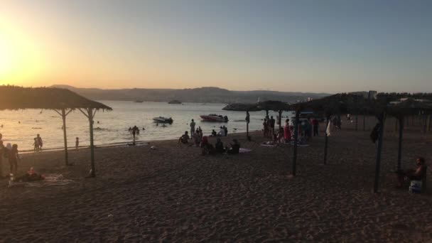 Aqaba, Jordanië - 15 oktober 2019: toeristen op het avondstrand van de rode zee — Stockvideo