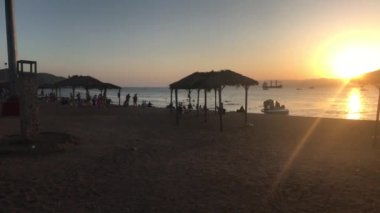 Akabe, Ürdün - 15 Ekim 2019: Kızıldeniz 'in akşam plajında turistler