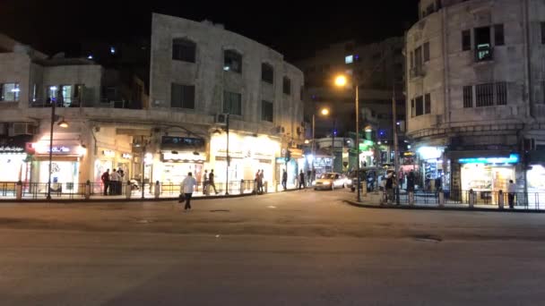 Амман (Йорданія) 15 жовтня 2019 року: туристи проходять через нічне місто вздовж магазинів. — стокове відео