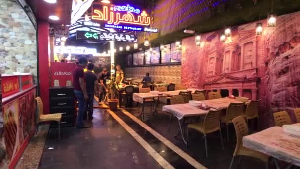 Amman, Jordanien - 15 oktober 2019: turister går genom nattstaden längs butiker par 2 — Stockvideo